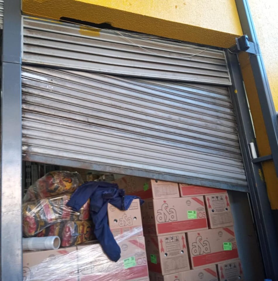 Técnico realizando manutenção em porta automática industrial